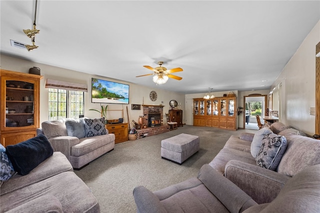 carpeted living area with a fireplace, visible vents, and a ceiling fan