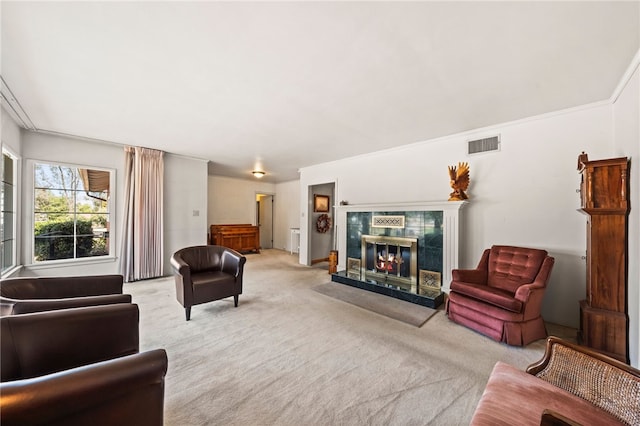 living room featuring crown molding, a tile fireplace, visible vents, and light colored carpet