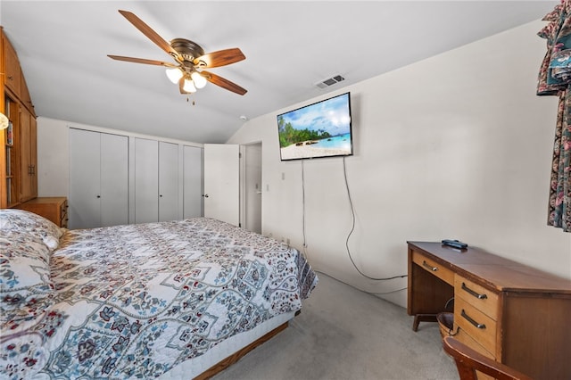 bedroom with light carpet, vaulted ceiling, visible vents, and a ceiling fan