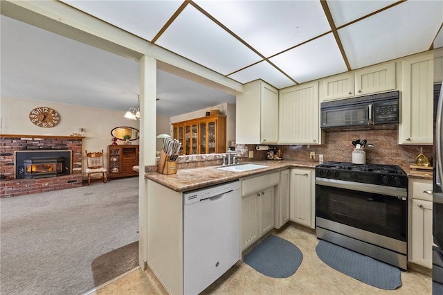 kitchen with black microwave, white dishwasher, light carpet, a sink, and stainless steel gas range