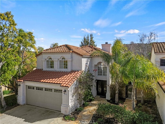 mediterranean / spanish home with driveway, a chimney, a tile roof, and stucco siding