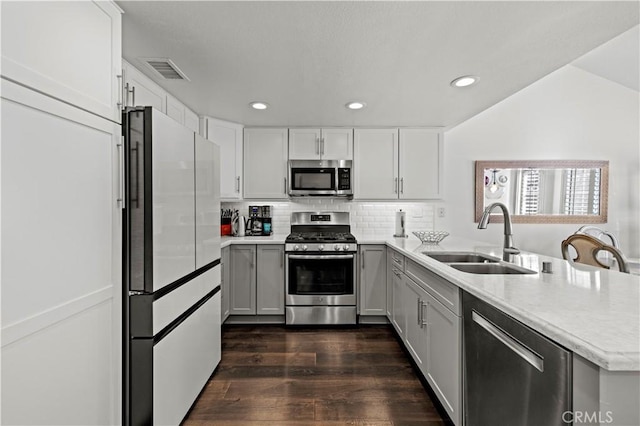 kitchen featuring stainless steel appliances, light countertops, a sink, and visible vents