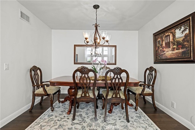 dining space featuring an inviting chandelier, baseboards, visible vents, and dark wood finished floors