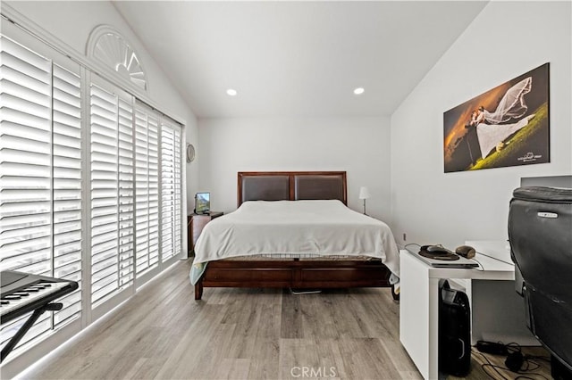 bedroom featuring light wood-type flooring, vaulted ceiling, and recessed lighting