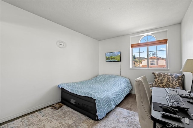 bedroom featuring baseboards and wood finished floors