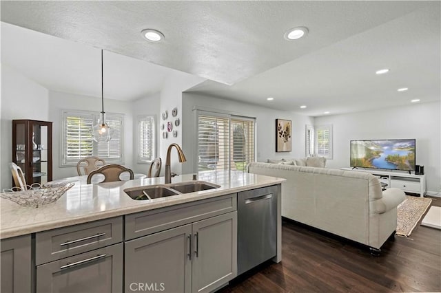 kitchen with open floor plan, a sink, hanging light fixtures, and gray cabinetry