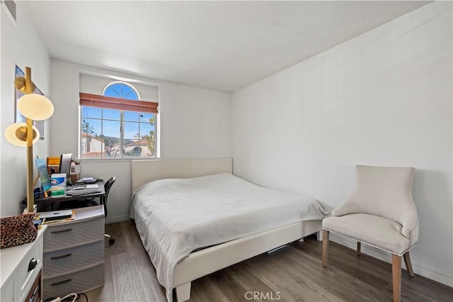 bedroom featuring baseboards and wood finished floors