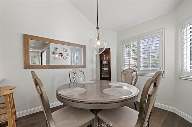 dining room with vaulted ceiling, dark wood-type flooring, and baseboards