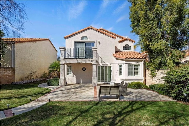 back of property featuring a balcony, fence, a patio, and stucco siding