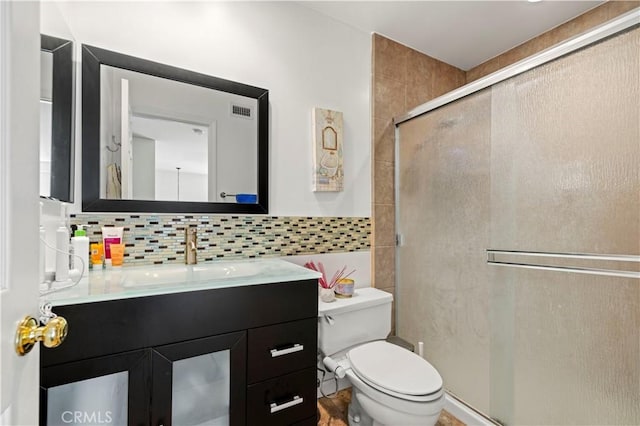 full bathroom featuring toilet, visible vents, vanity, tasteful backsplash, and a stall shower