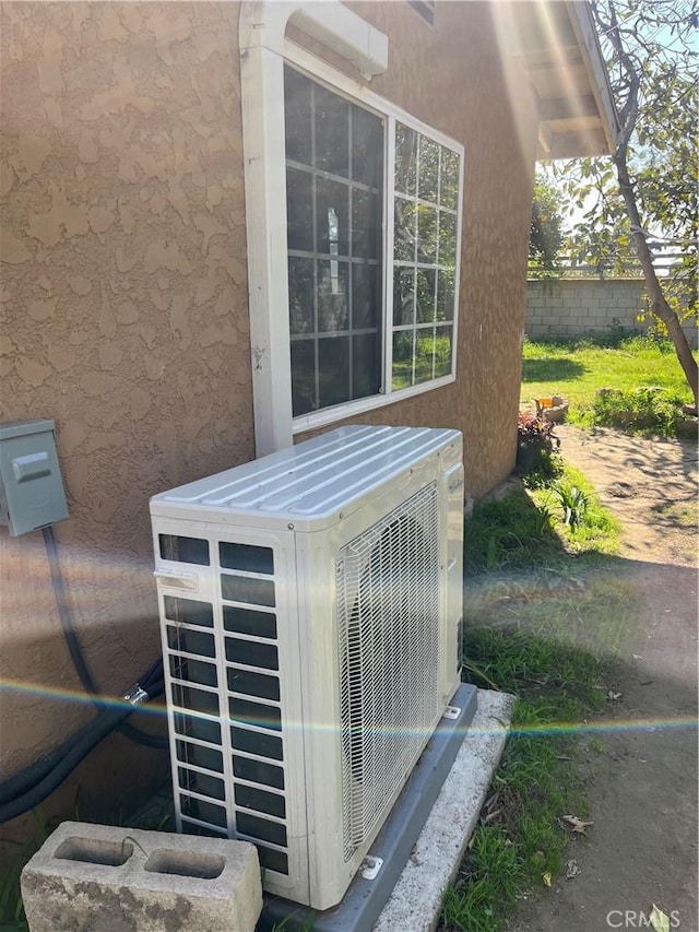 exterior details featuring ac unit, fence, and stucco siding