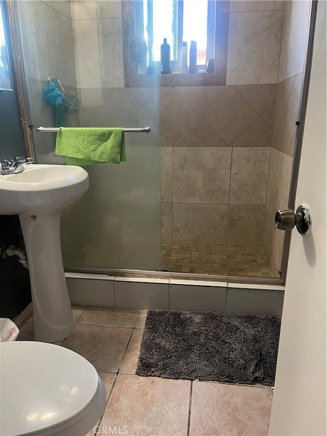 full bathroom with tile patterned flooring, a shower stall, and toilet