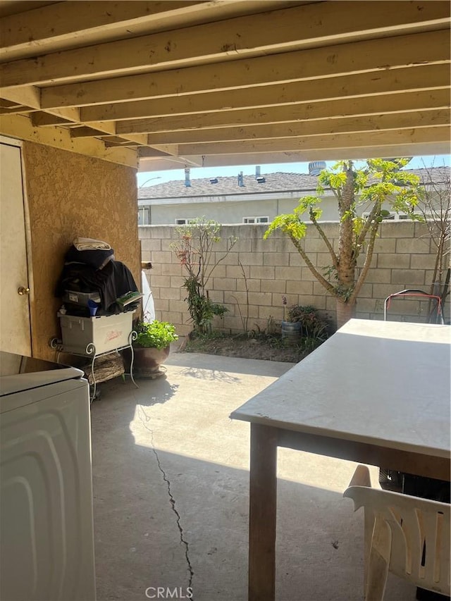 view of patio / terrace featuring washer / clothes dryer and fence