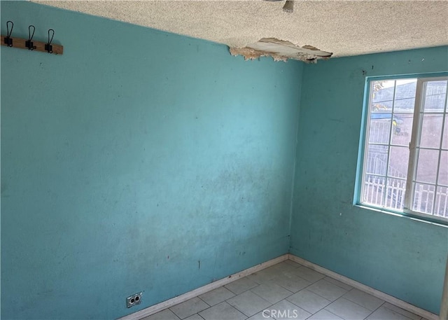 empty room featuring a textured ceiling and baseboards