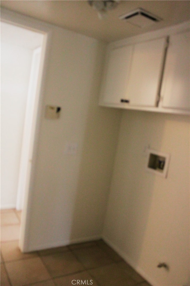 washroom featuring cabinet space, visible vents, washer hookup, and tile patterned floors