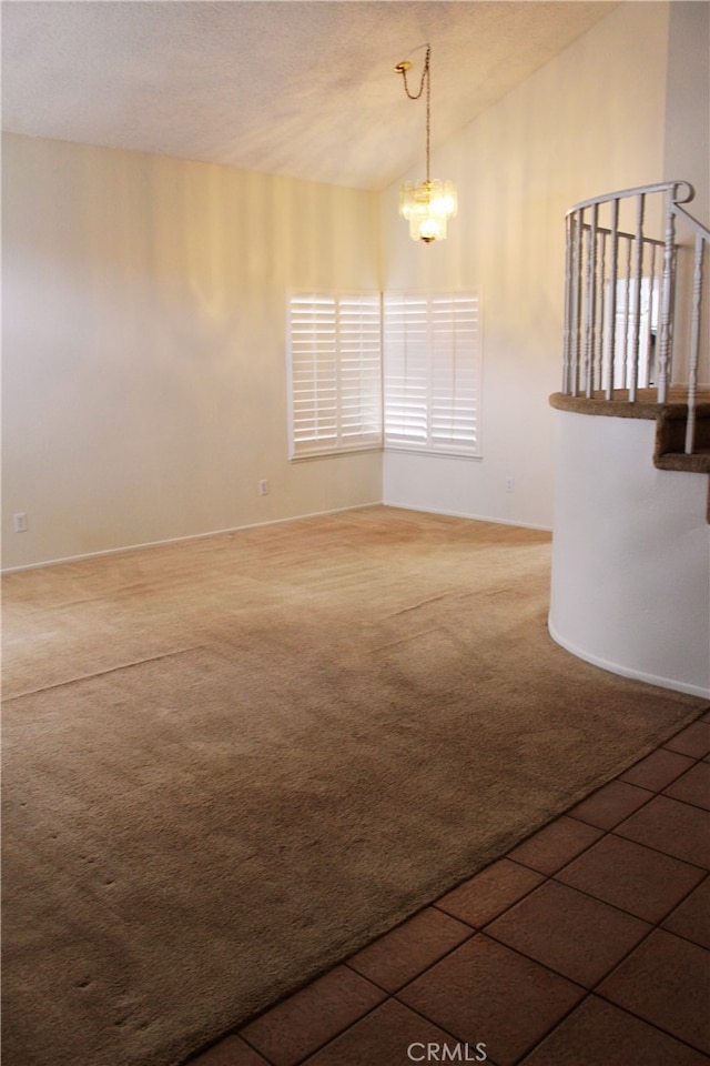 empty room with an inviting chandelier, vaulted ceiling, stairway, and dark colored carpet