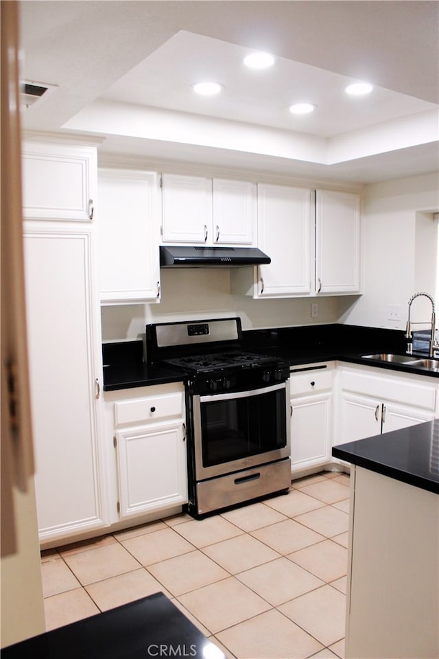 kitchen featuring stainless steel gas range, white cabinetry, a sink, and under cabinet range hood