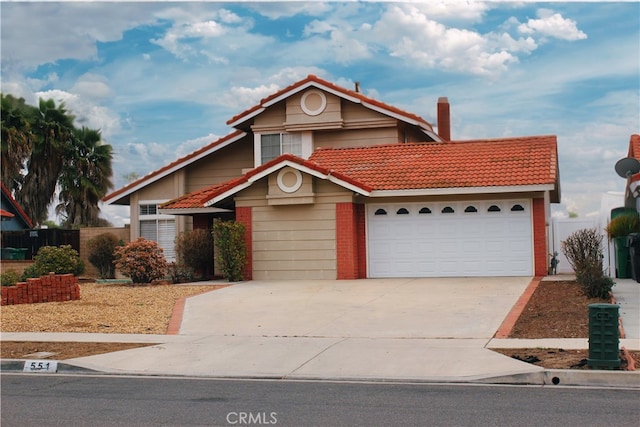 view of front of property with an attached garage, a tiled roof, a chimney, and concrete driveway