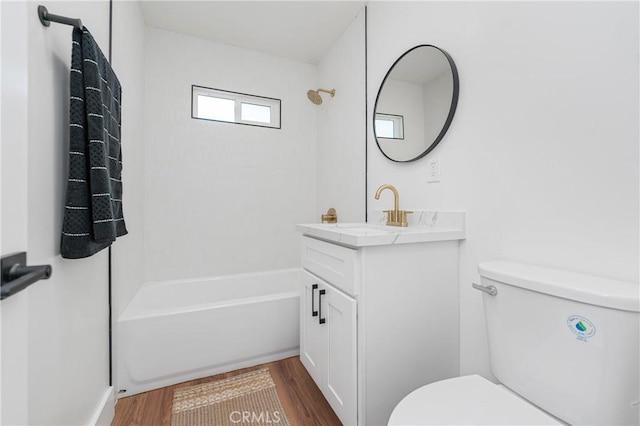 bathroom featuring toilet, shower / tub combination, wood finished floors, and vanity