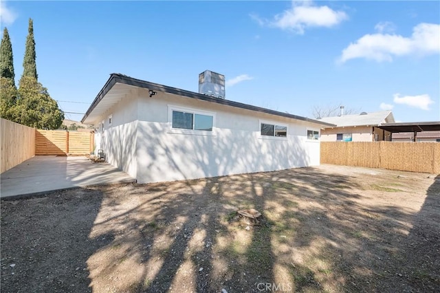 back of property featuring a fenced backyard, a patio, and a chimney