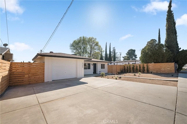 view of front of property with driveway, an attached garage, and fence