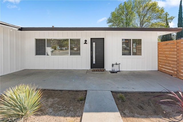 doorway to property featuring a patio area and fence