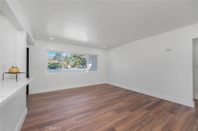 unfurnished living room featuring recessed lighting, baseboards, and wood finished floors