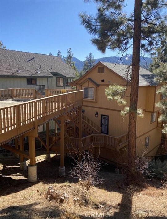 back of house with a deck with mountain view and stairs