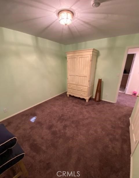 unfurnished bedroom featuring baseboards and dark carpet