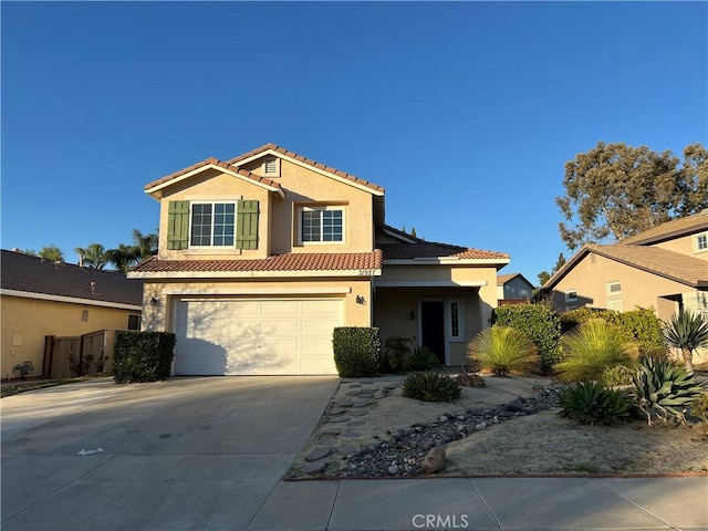 view of front facade featuring driveway, an attached garage, a tiled roof, and stucco siding