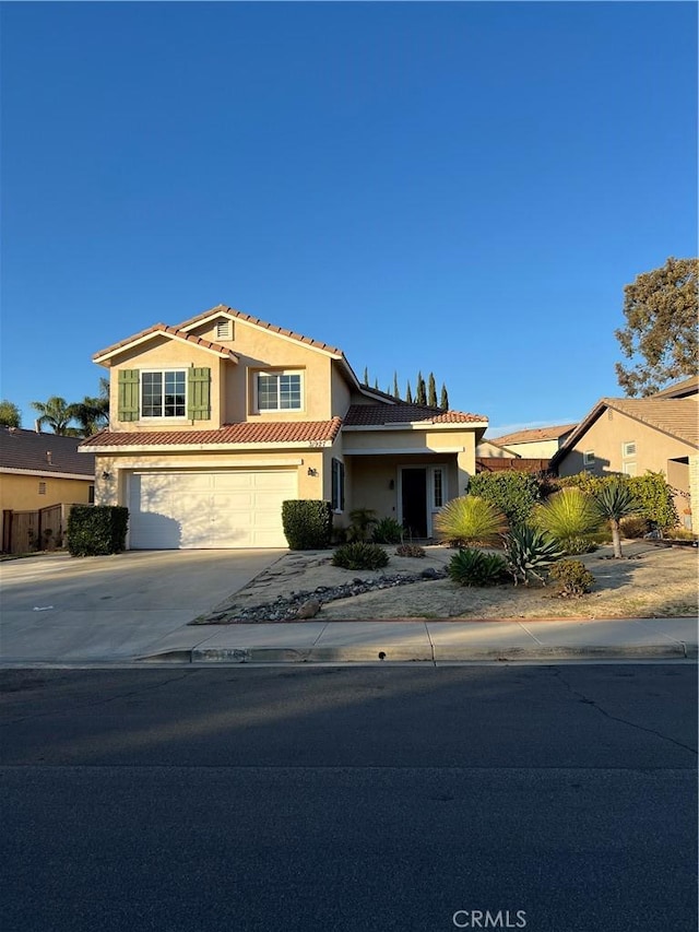 view of front of house featuring driveway, a tile roof, and stucco siding