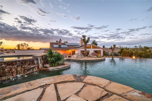 pool with an in ground hot tub and a patio