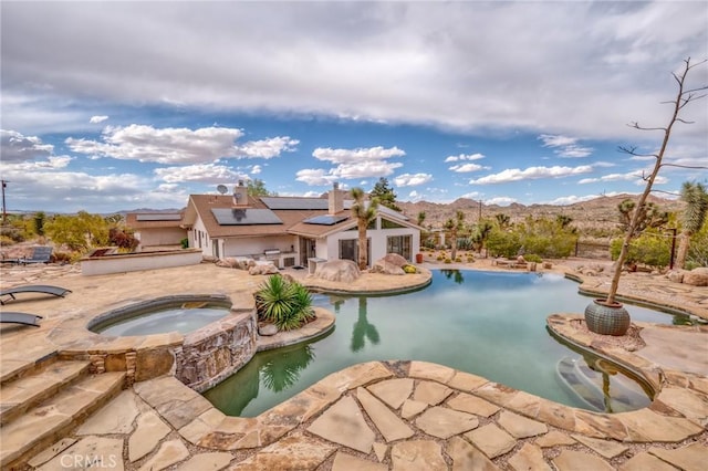 pool with a patio area and an in ground hot tub