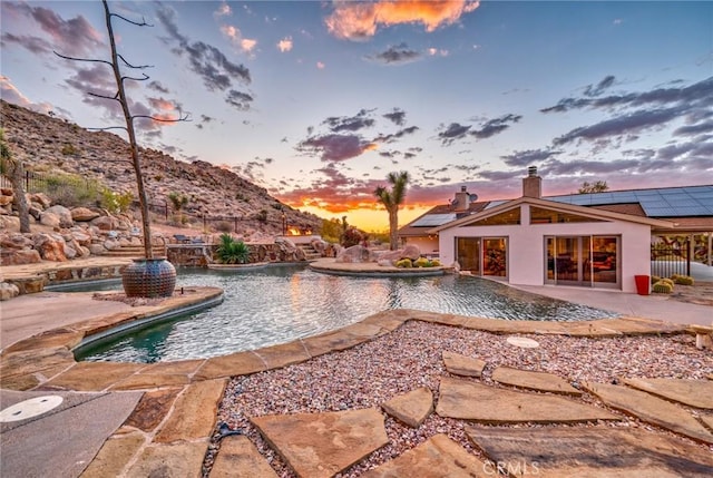 pool with a patio area and fence