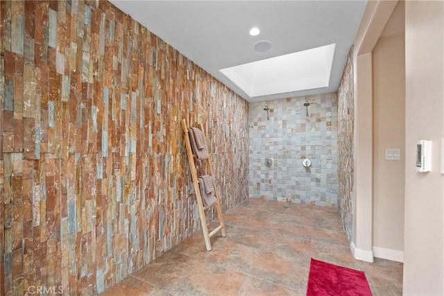 bathroom featuring a skylight and tiled shower