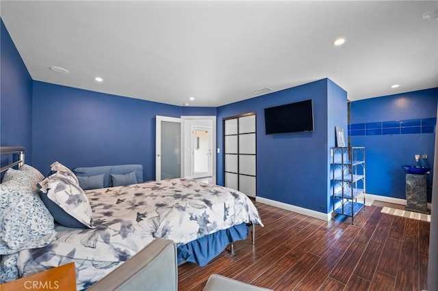 bedroom with baseboards, wood finished floors, and recessed lighting