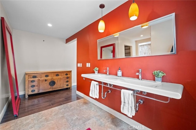 bathroom featuring baseboards, wood finished floors, and recessed lighting