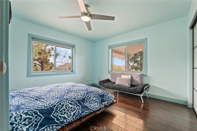 bedroom featuring ceiling fan, a closet, baseboards, and wood finished floors