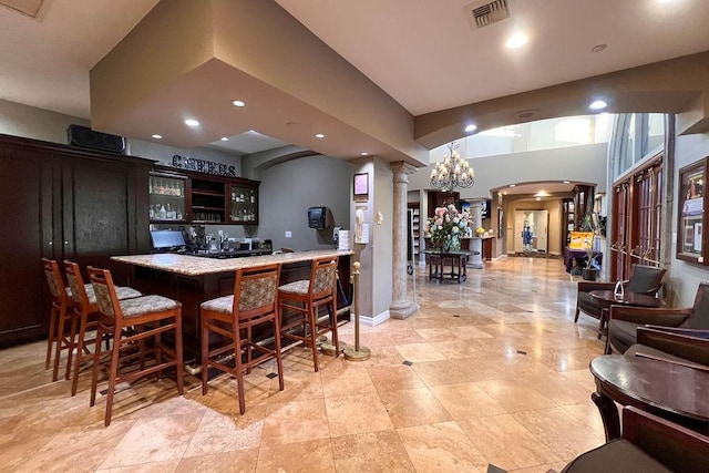 bar featuring visible vents, recessed lighting, wet bar, decorative columns, and arched walkways