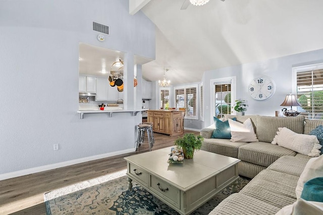 living room featuring high vaulted ceiling, wood finished floors, beamed ceiling, baseboards, and visible vents