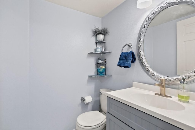 half bathroom featuring vanity and toilet