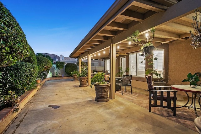 view of patio / terrace featuring a ceiling fan, fence, and a mountain view