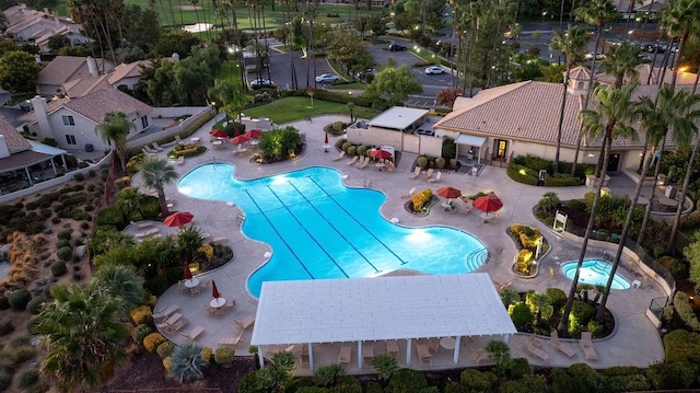 pool with a hot tub and a patio