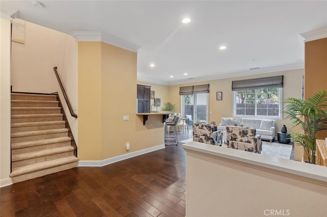 unfurnished living room with ornamental molding, dark wood-style flooring, baseboards, and stairs