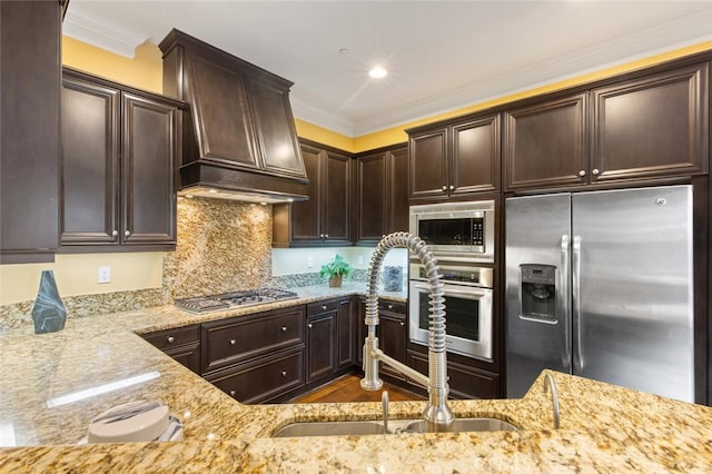 kitchen featuring custom range hood, stainless steel appliances, a sink, and light stone countertops