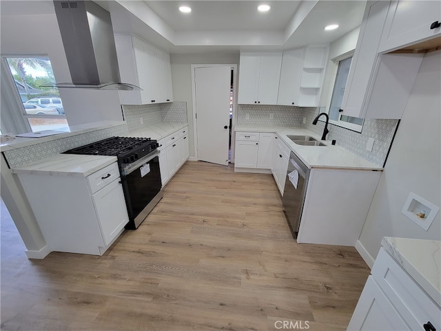 kitchen with wall chimney range hood, dishwasher, light wood-style flooring, gas stove, and a sink