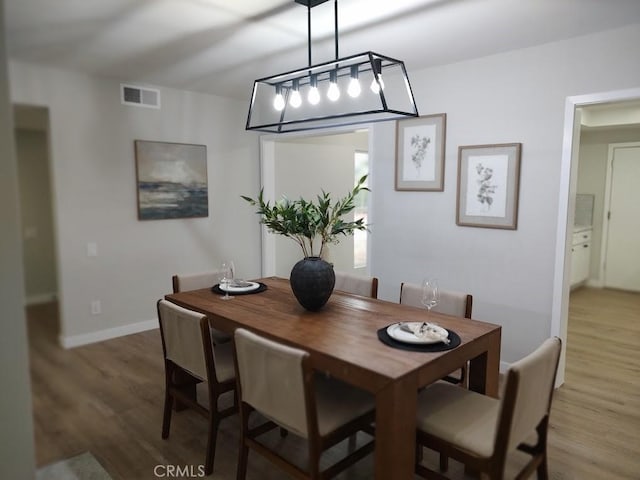 dining space with visible vents, baseboards, and light wood-style floors