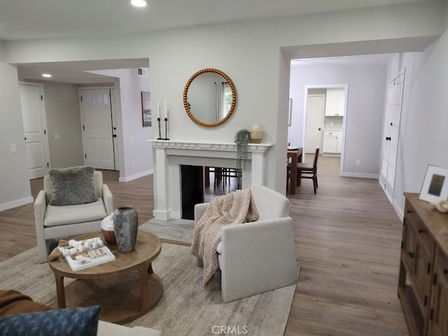 living room featuring recessed lighting, wood finished floors, and baseboards