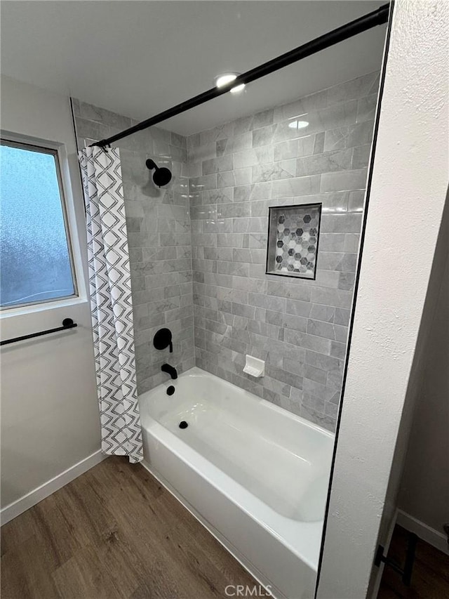 full bathroom with wood finished floors, shower / bath combo, and baseboards