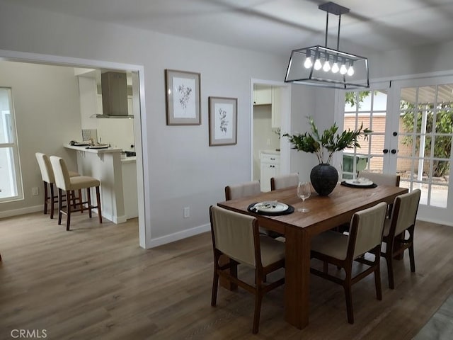 dining space with baseboards and wood finished floors